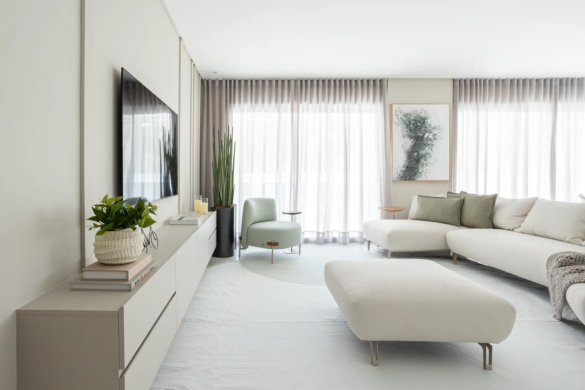 Living claro em off-white com sofá verde-oliva, no Apartamento Guarujá