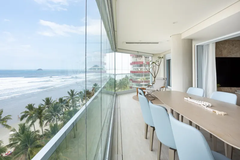Mesa de jantar diante da parede de vidro com vista panorâmica do mar