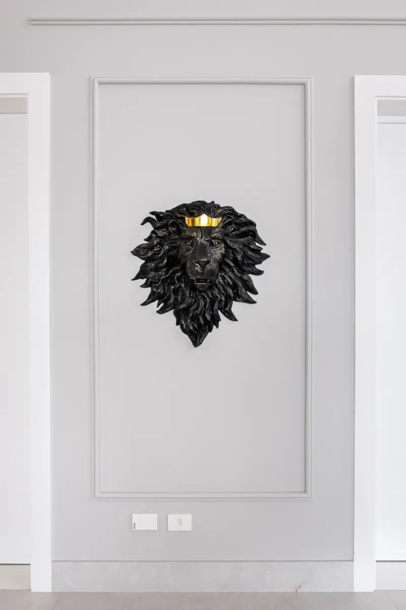 Parede de boiserie cinza-claro simétrica com escultura ao centro