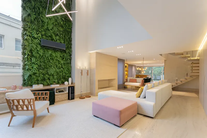 Living de pé-direito duplo com jardim vertical e paleta pastel