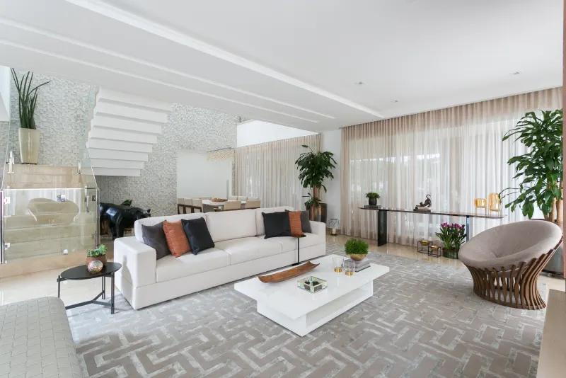 Living branco com escada escultural e parede de mosaico 3D